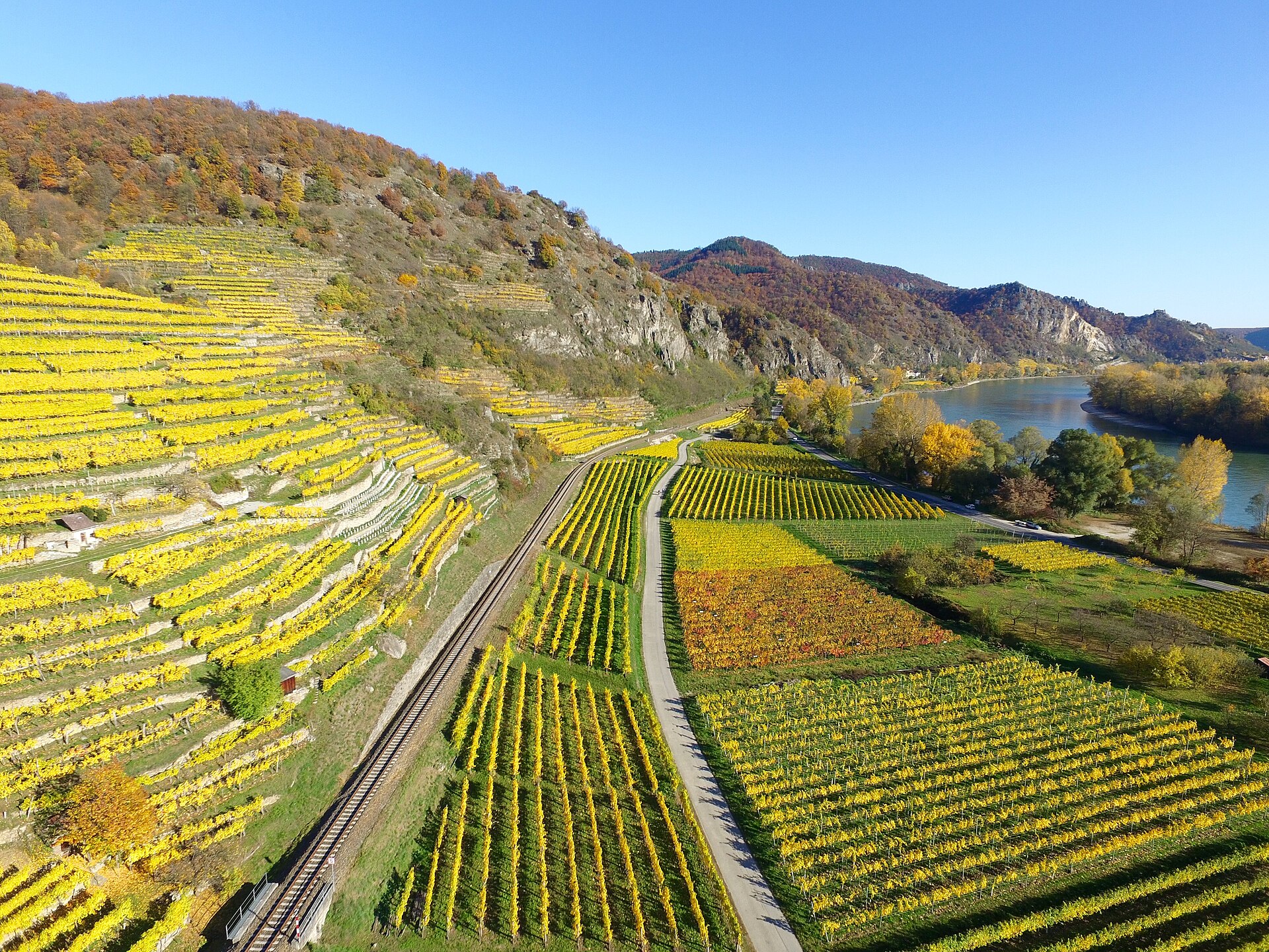 Il pittoresco borgo azzurro di Dürnstein si specchia nelle acque del Danubio tra i vigneti autunnali della Wachau.