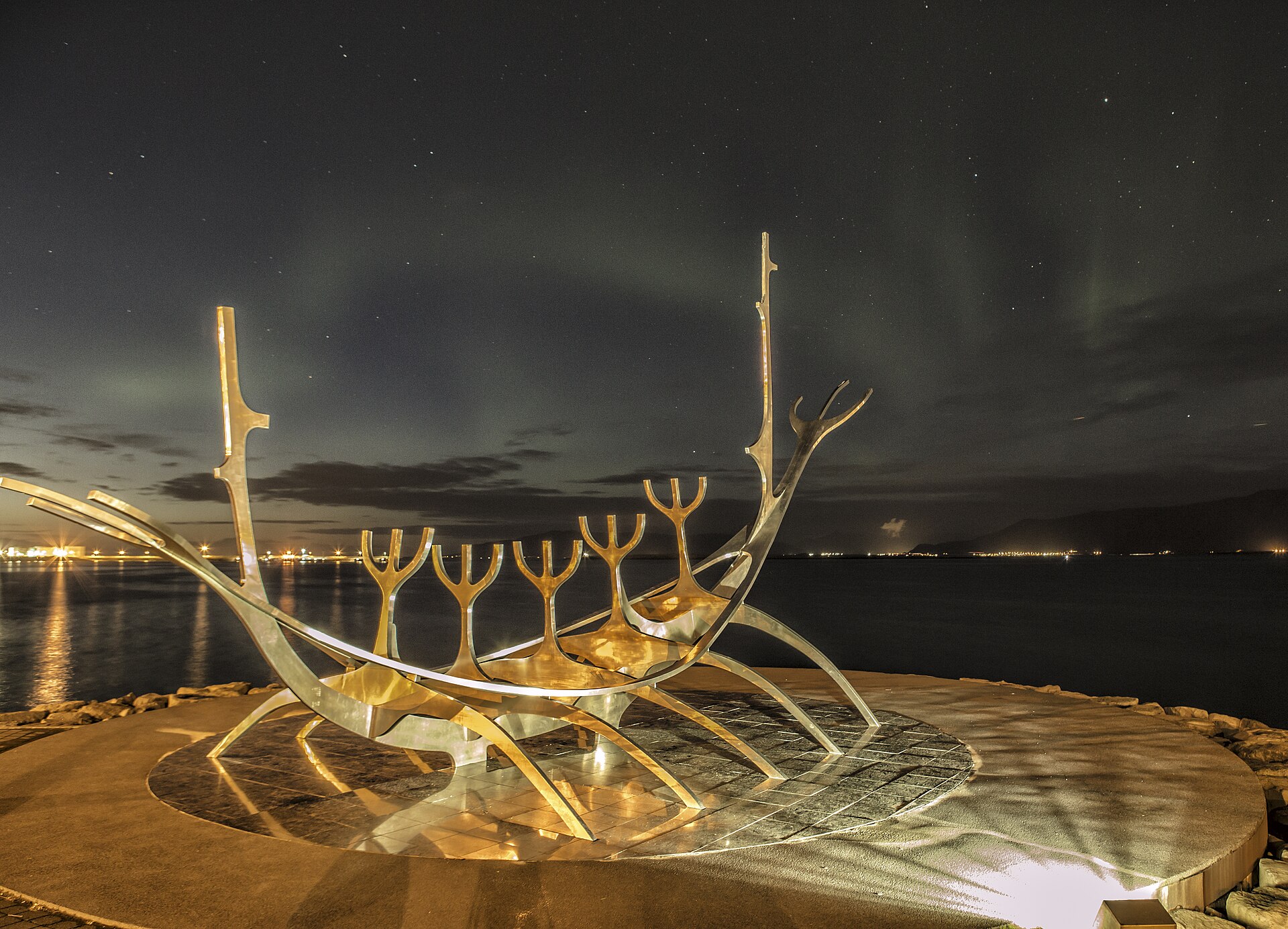 Aurora boreale sul Sun Voyager nel centro di Reykjavik, con la caratteristica scultura illuminata dai colori del fenomeno luminoso.