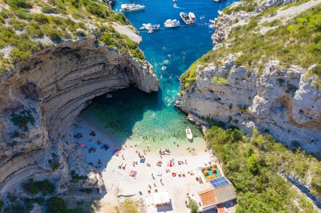 La spiaggia di Stiniva sull'isola di Vis, una caletta chiusa tra alte scogliere, vista dall'alto