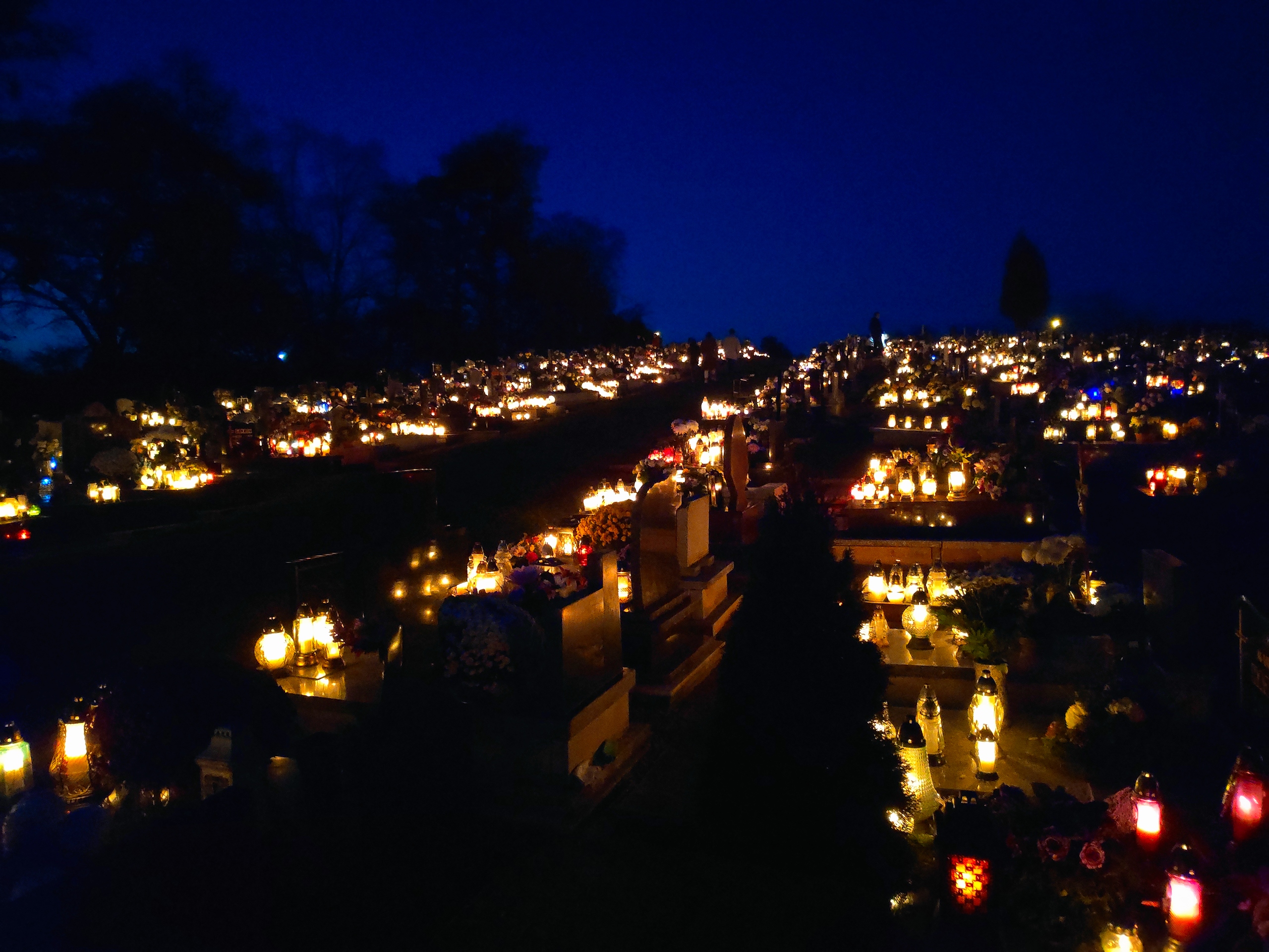I lumini accesi sulle tombe la sera di Ognissanti, in un cimitero della Polonia.