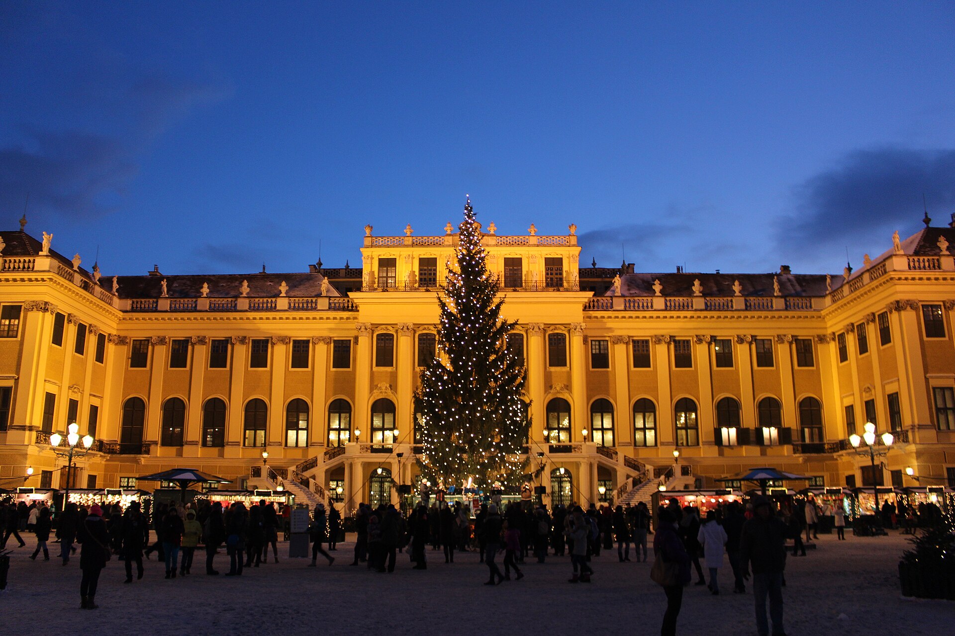 Il Mercatino di Natale al Palazzo di Schönbrunn a Vienna, con le bancarelle decorate e l'atmosfera festiva della rinomata piazza natalizia viennese.