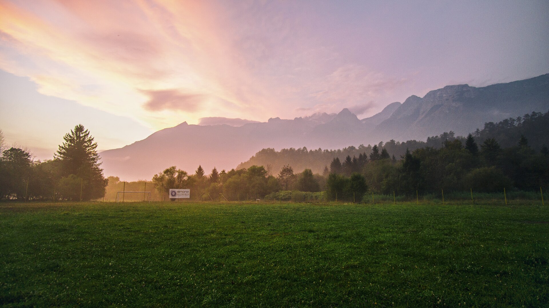 Il Triglav National Park in autunno, con le montagne avvolte dalla nebbia e dai colori caldi del tramonto.